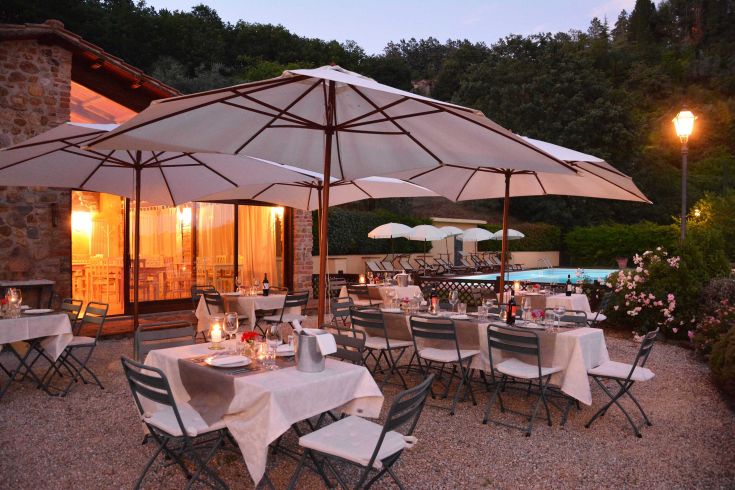 Restaurant mit Tischgelegenheiten im Freien, eingebettet in eine ruhige und angenehme Naturlandschaft.