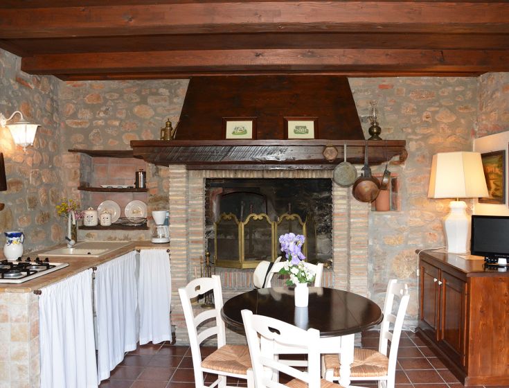 Rustikale Küche mit Kamin und Essensvorbereitungsbereich, ideal für Familienmomente.