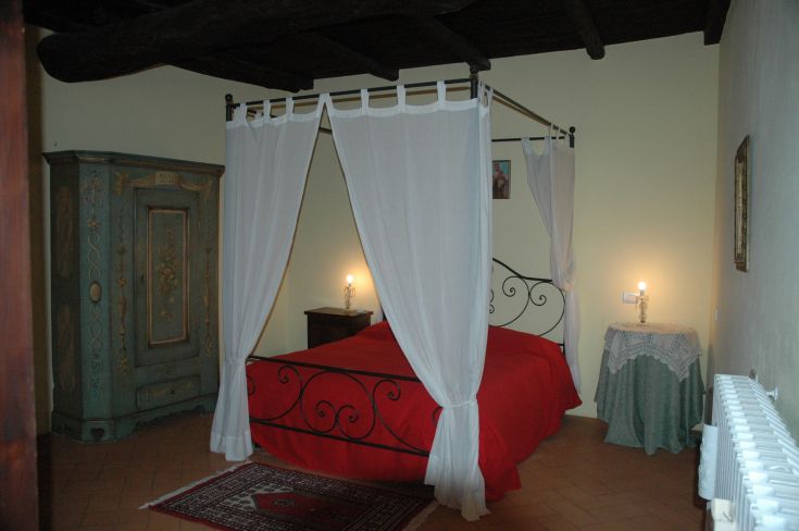 Simple double bedroom with wrought iron beds, rustic furniture, and a cozy, serene atmosphere.