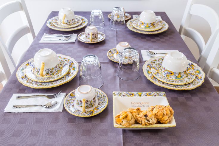 A neatly arranged table with brightly colored dishes and some sweets.