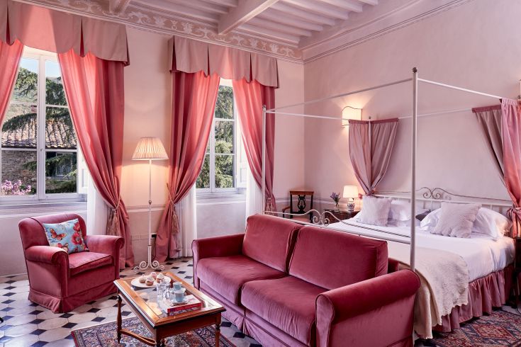 Camera con letti a baldacchino e dettagli in tonalità rosa.