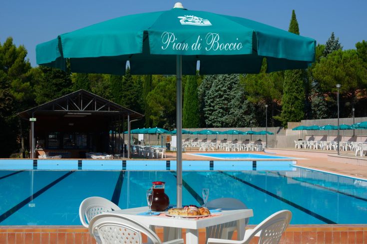 Un'area piscina attrezzata con ombrelloni e tavoli, ideale per momenti di relax.