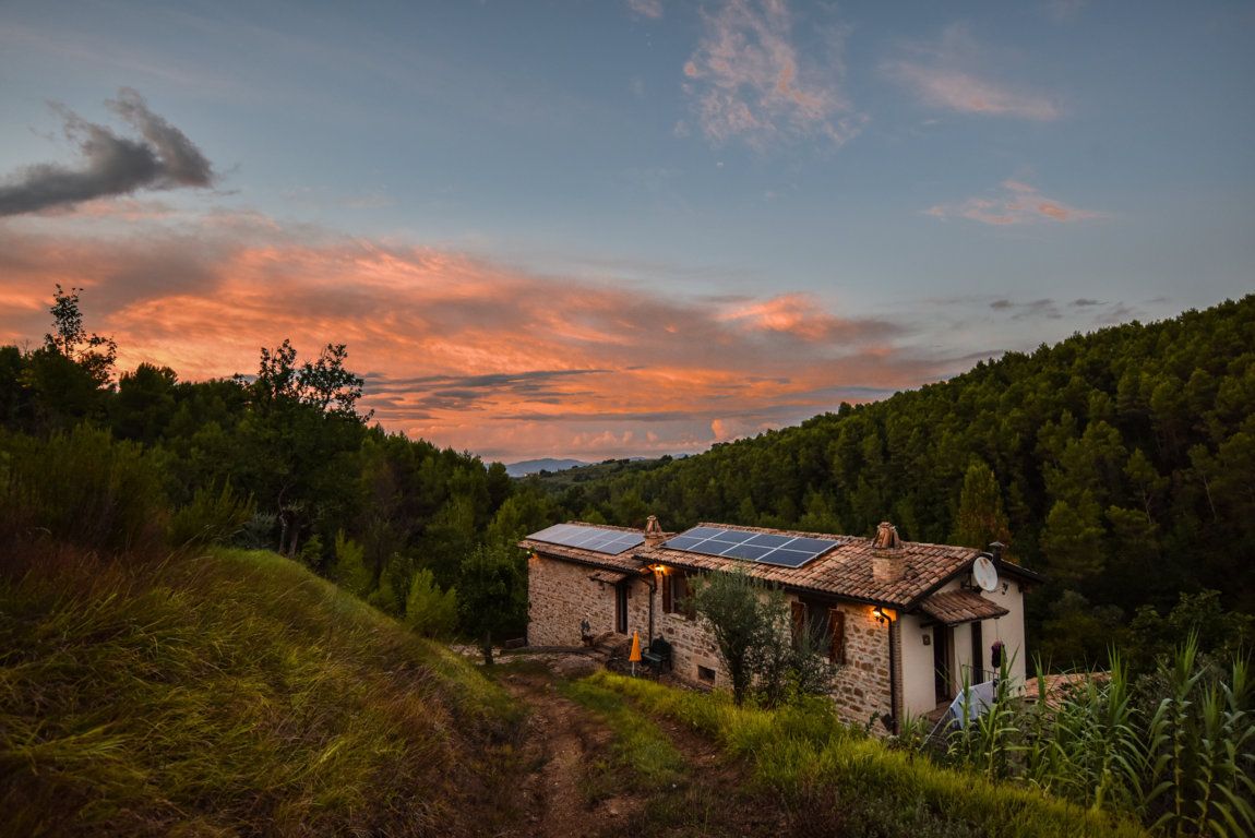 A building surrounded by nature, set under a clear sky during sunset.