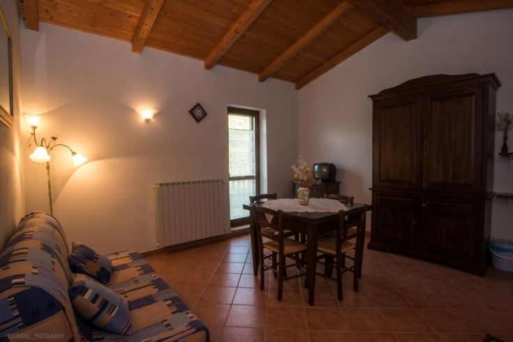 Un salon accueillant avec des meubles en bois et une table à manger mise pour les repas.