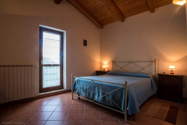 Chambre simple et accueillante avec lit double et éclairage doux, parfaite pour un séjour relaxant.