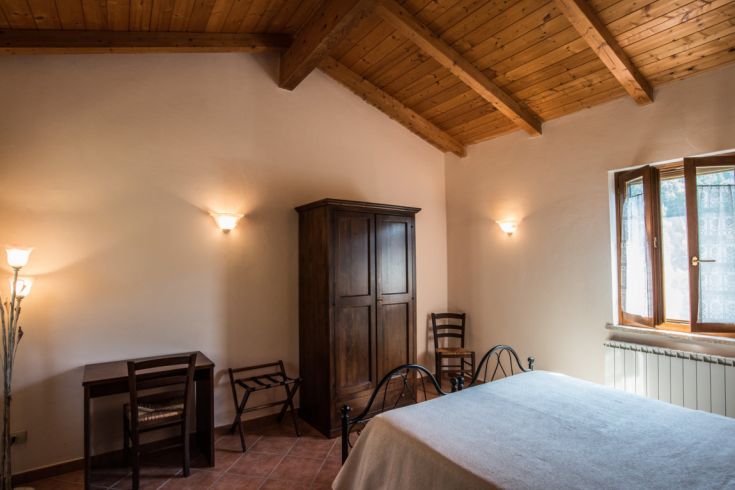 Chambre double en bois avec décor simple et vue sur la nature environnante.