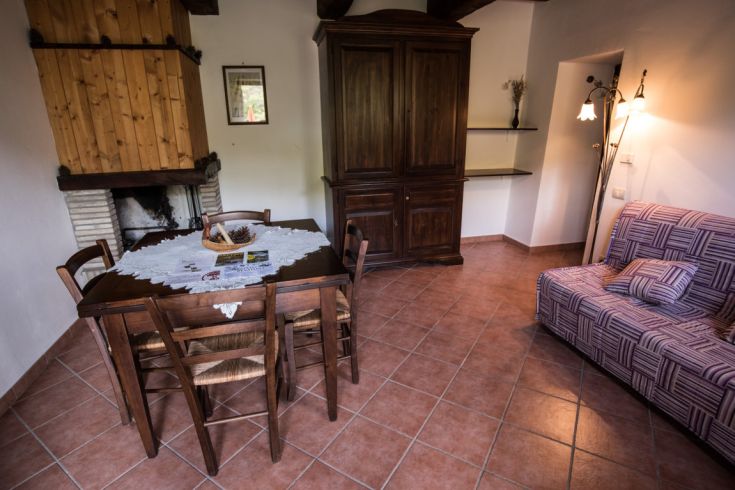 Salon de ferme confortable avec une table en bois et un canapé pour des moments de détente.