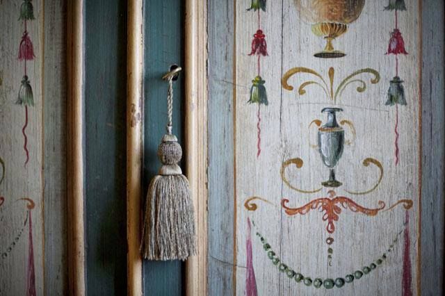 Dettagli di un rivestimento murale decorato, caratterizzato da una frangia sobria.