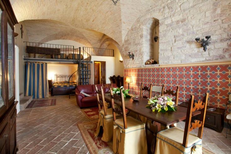 Interno semplice di un palazzo, con arredi rustici e un'atmosfera calda.