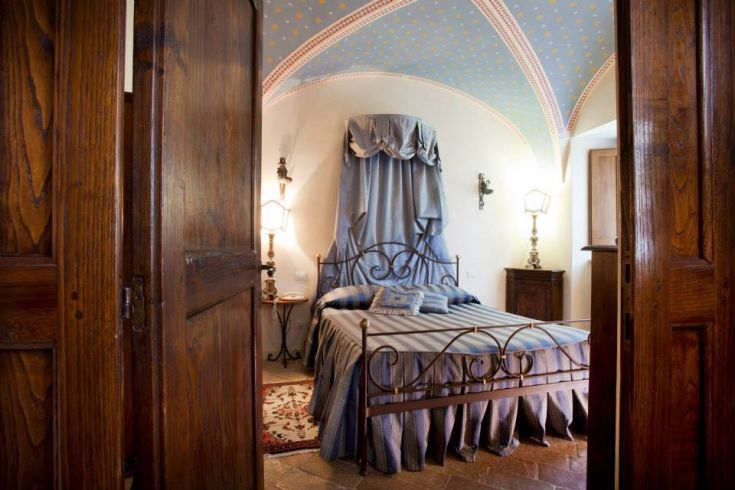 Interno semplice di un palazzo storico, con soffitto decorato e mobili in stile tradizionale.