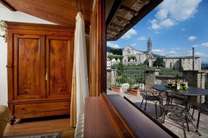 Panorama su Assisi da una residenza storica con elementi architettonici classici.