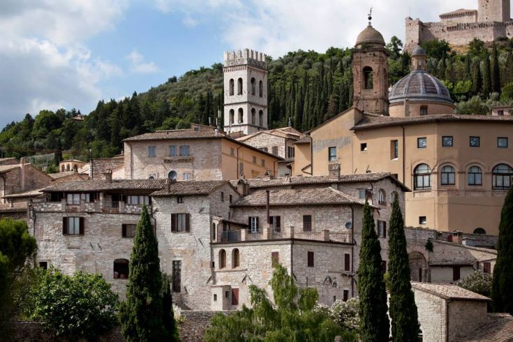 Panorama di un suggestivo borgo storico caratterizzato da torri e abitazioni in pietra.
