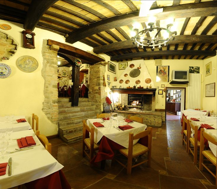 Un locale intimo con arredi semplici e un'atmosfera calda, arricchito da un camino e dettagli rustici.