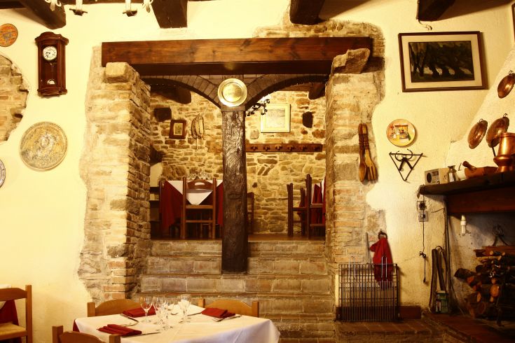 Interno di un ristorante con arredi semplici e un'atmosfera calda e invitante.