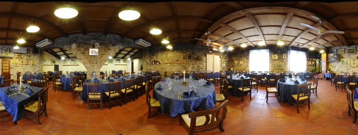 Una sala ristorante intima con tavoli ben apparecchiati e alcune decorazioni classiche.