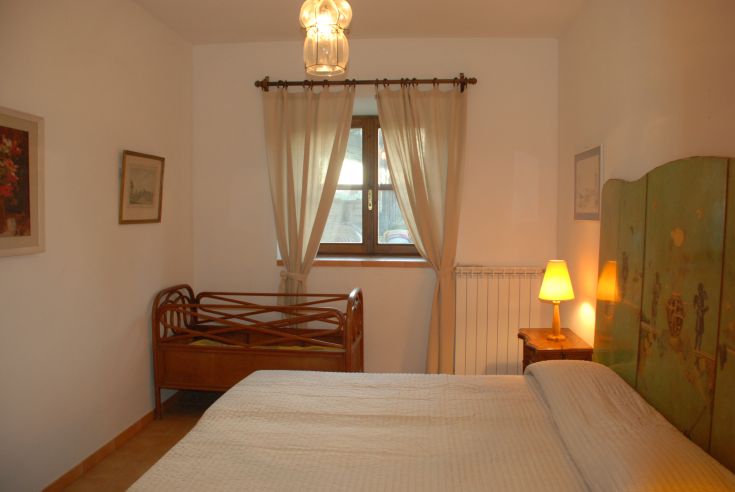 Stanza confortevole con letti, lampada e decorazioni sobrie in stile rustico.