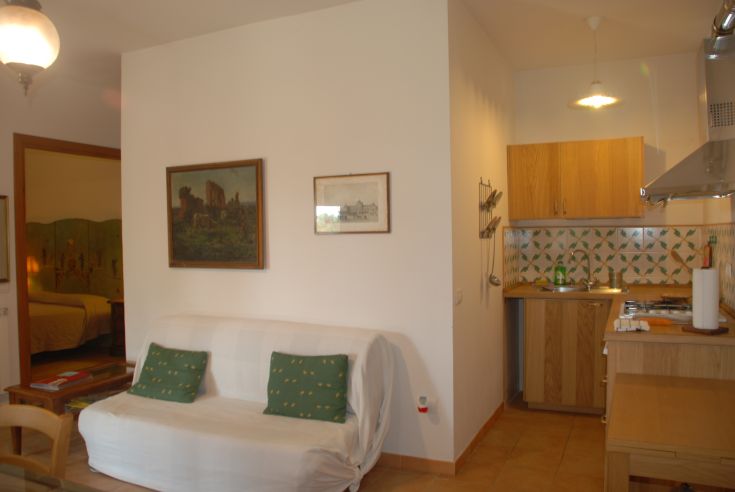 Ambiente confortevole composto da soggiorno e cucina, arredato in modo semplice e funzionale.