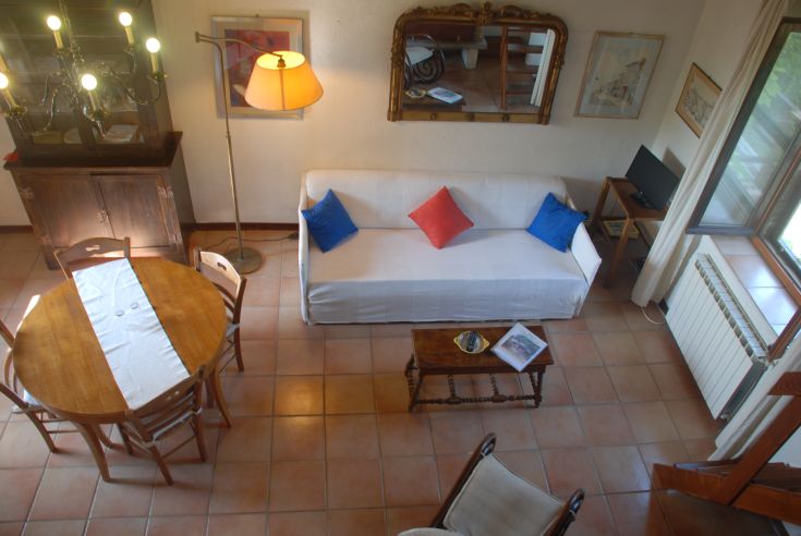 Interno semplice di un appartamento con divano e tavolo da pranzo.