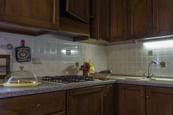 Cucina in legno con elementi semplici, ideale per pasti in compagnia e preparazioni casalinghe.