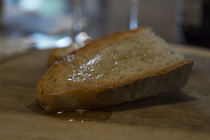 Una fetta di pane con miele dorato sopra, posata su un piatto bianco. Immagine semplice e accogliente.