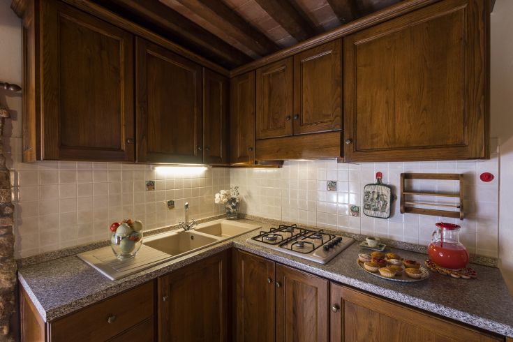 Cucina semplice in legno, con lavello e piano cottura, ideale per piacevoli momenti in famiglia.