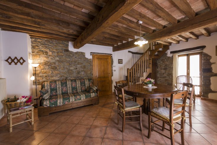 Un soggiorno semplice con elementi in legno e pietra, ideale per spazi di relax.