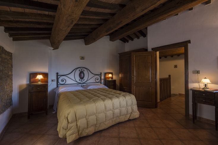 Camera semplice con un letto matrimoniale e mobili in legno, perfetta per un soggiorno tranquillo.