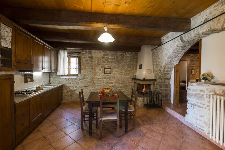 Cucina in stile rustico, con arredi in legno e dettagli in pietra, dal design semplice e confortevole.