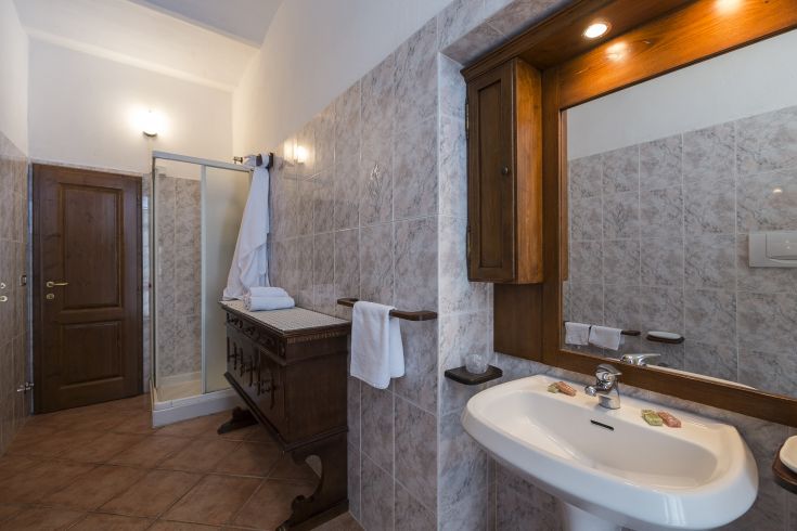 Un bagno curato con elementi in legno e piastrelle, caratterizzato da una palette di toni neutri.