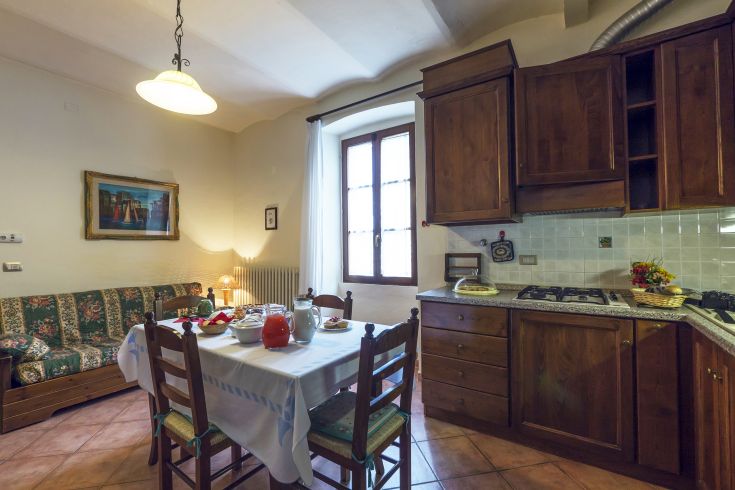 Una cucina semplice e funzionale con area pranzo, ideale per trascorrere del tempo insieme a famiglia e amici.