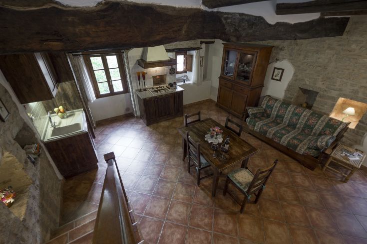 Un'accogliente cucina-soggiorno con arredo semplice e panorama sulla natura circostante.