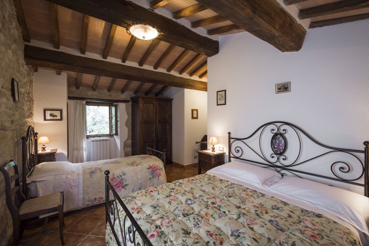 Una camera semplice e rustica con elementi in ferro battuto e decorazioni floreali discrete.