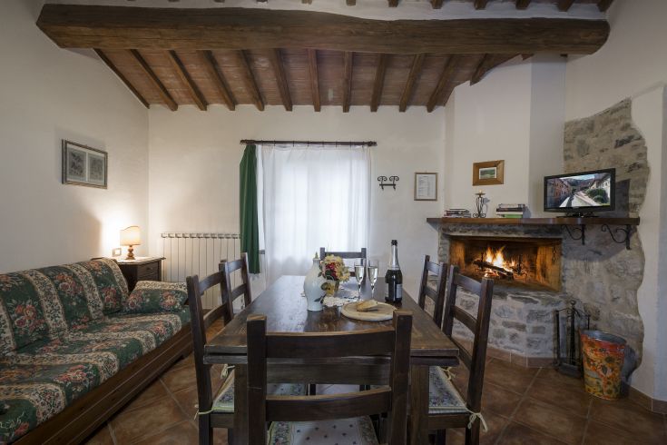 Ambiente interno con un tavolo apparecchiato e un camino, ideale per trascorrere momenti in compagnia.
