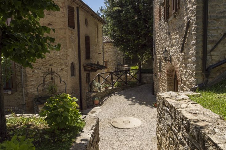 Un angolo caratteristico del paesaggio rurale, circondato da edifici in pietra e verde naturale.