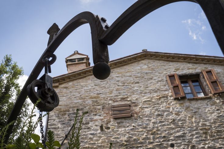 Un angolo di campagna accogliente, con un edificio in pietra e un cancello in ferro.