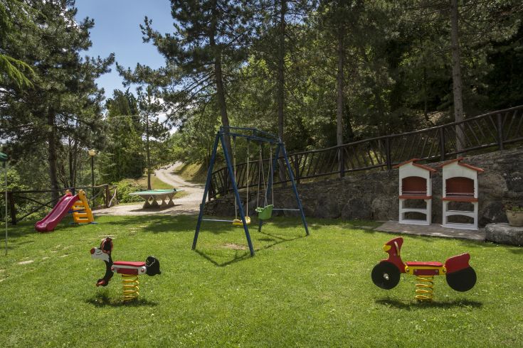 Un'area giochi situata in uno spazio verde, adatta ai bambini, con giochi dai colori vivaci.