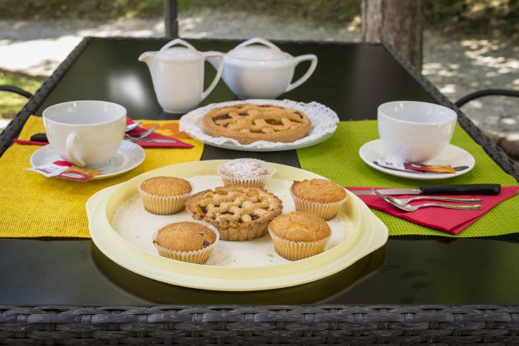 Tè pomeridiano servito con dolci in un contesto semplice e naturale.