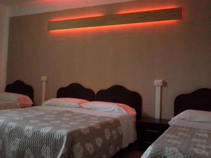 Well-organized room with arranged beds and soft red lighting.
