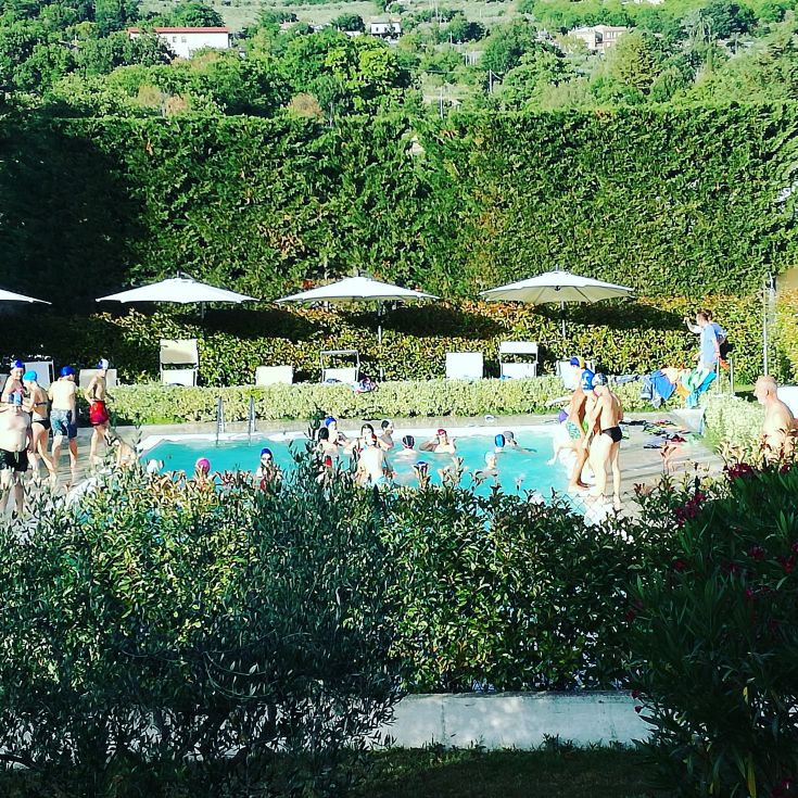 A peaceful afternoon by the pool, as people relax under umbrellas.