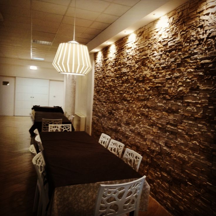 Functional interior with tidy tables and a simple stone wall.