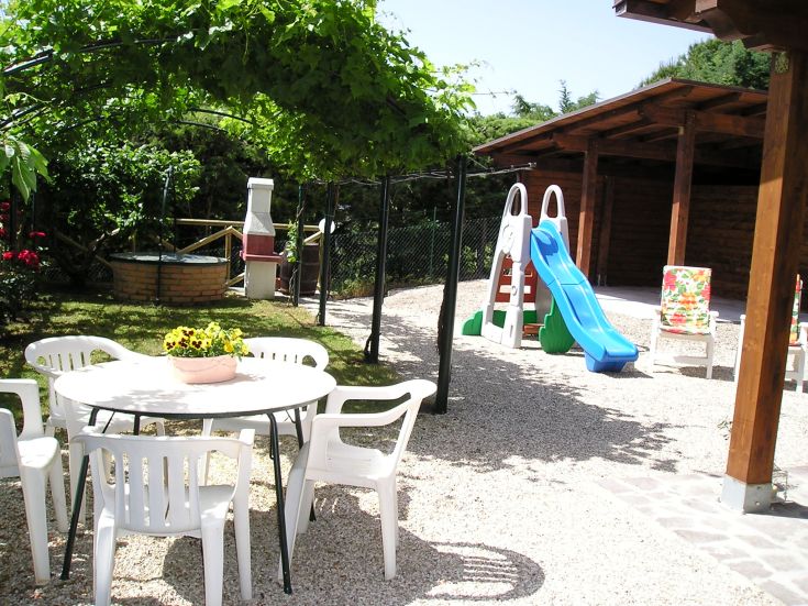 Un jardin lumineux avec une aire de jeux et une table pour profiter de moments de détente en plein air.