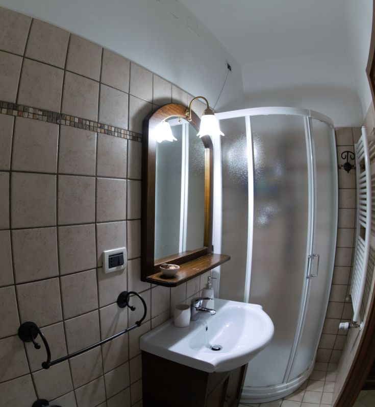 Une salle de bain contemporaine avec une douche et un miroir simple. Sols en carrelage et une atmosphère agréable.