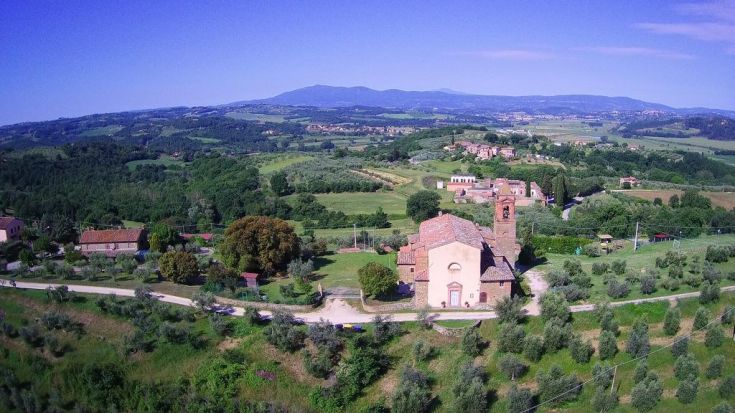 Panorama su dolci colline con una chiesa e alcuni casali sparsi nella zona.