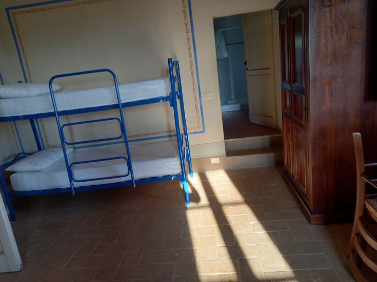 Camera spaziosa con letti a castello, ben illuminata, adatta a momenti di svago e socializzazione.