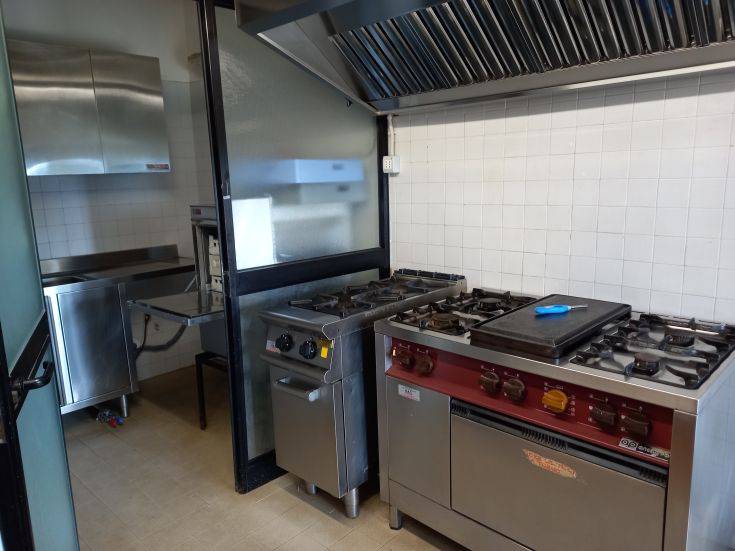 Cucina dotata di elettrodomestici adatti per attività di ristorazione.
