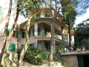 A building located on a hill, surrounded by a garden in a quiet area with a beautiful view.