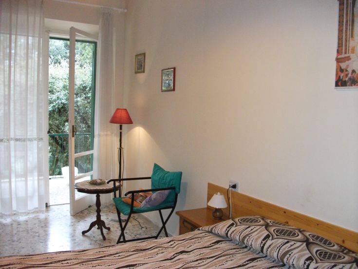 The B&B room offers a bright, simple atmosphere overlooking a well-maintained garden.