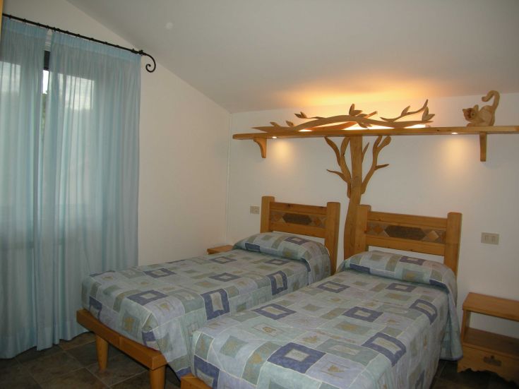 Einfache Agriturismo-Zimmer, ideal zur Entspannung. Bequeme Betten und Holzelemente schaffen eine gemütliche Atmosphäre.
