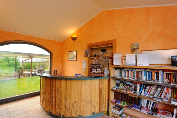 Rezeption eines Ferienbauernhofs, umgeben von Natur, mit Entspannungsbereichen und Wellness-Anwendungen.