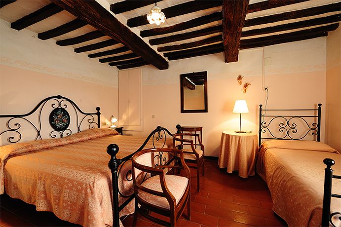 Ruhiges Schlafzimmer mit einfachen Betten und rustikaler Dekoration, sanft beleuchtet von gedämpften Lichtern.